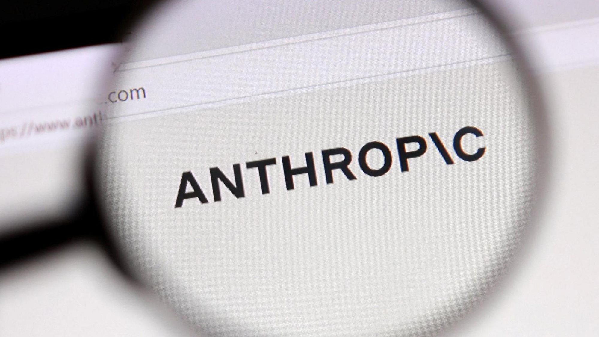De naam Anthropic vergroot bekeken door een loep op een computerscherm