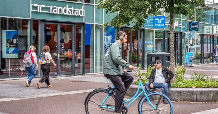 Vestiging van uitzendbureau Randstad aan een winkelstraat met voorbijgangers