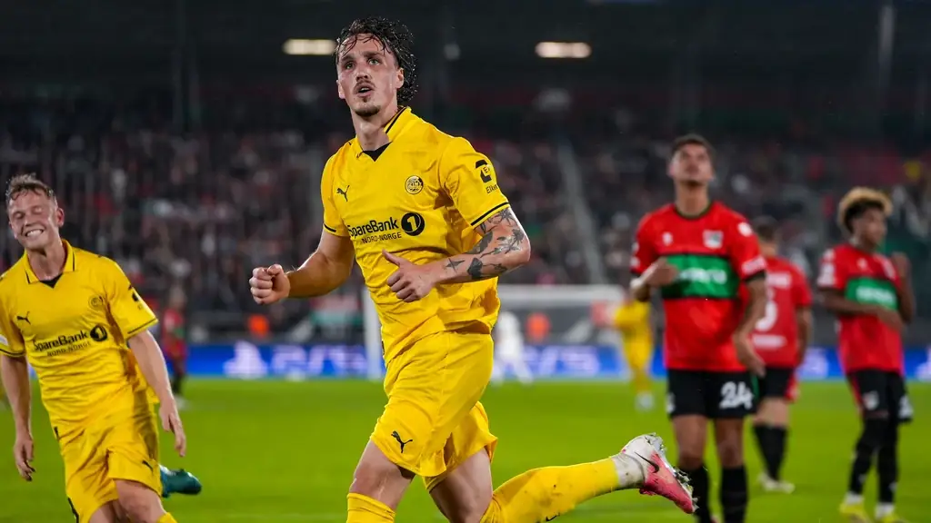 Spelers van Bodø/Glimt vieren een doelpunt terwijl NEC-spelers in rood-groen shirt teleurgesteld toekijken