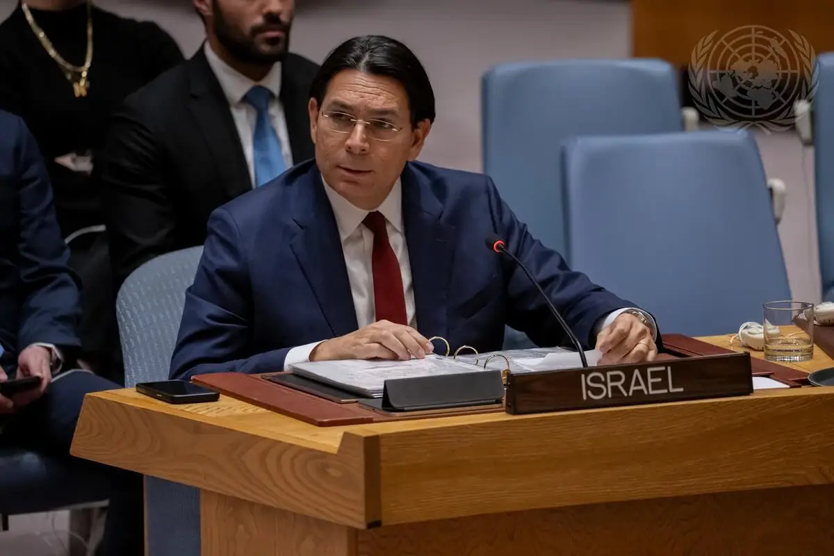 Danny Danon zit aan een naambordje met "Israel" tijdens een VN-zitting, met United Nations-logo op de achtergrond
