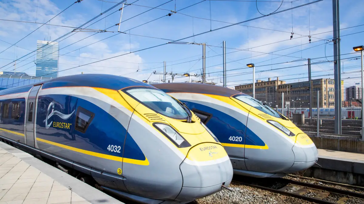 Twee blauw met gele Eurostar-hogesnelheidstreinen met de nummers 4032 en 4020 staan naast elkaar aan het perron onder bovenleiding