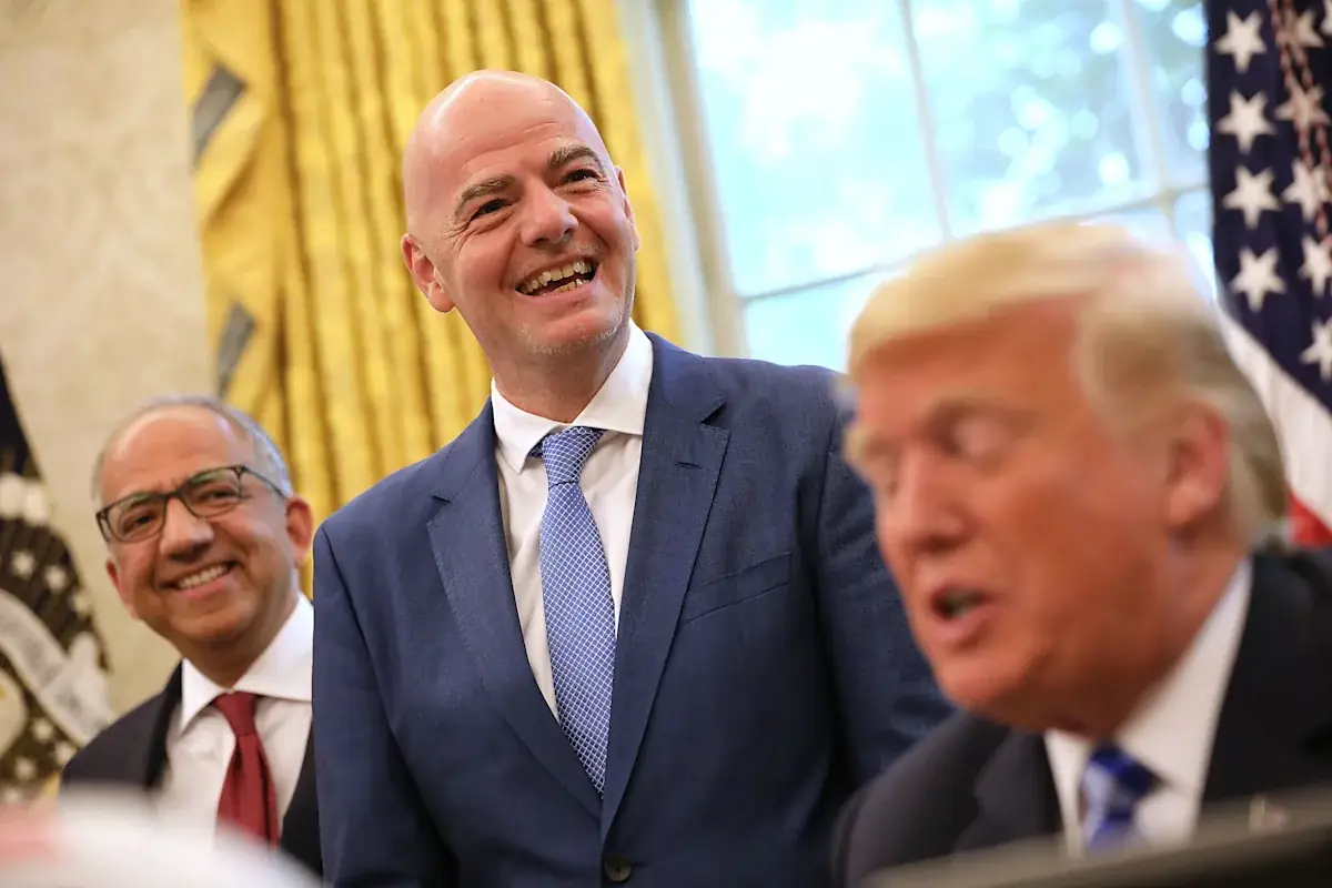Gianni Infantino lacht tijdens een bijeenkomst in het Oval Office, met Carlos Cordeiro links achter hem en president Trump op de voorgrond