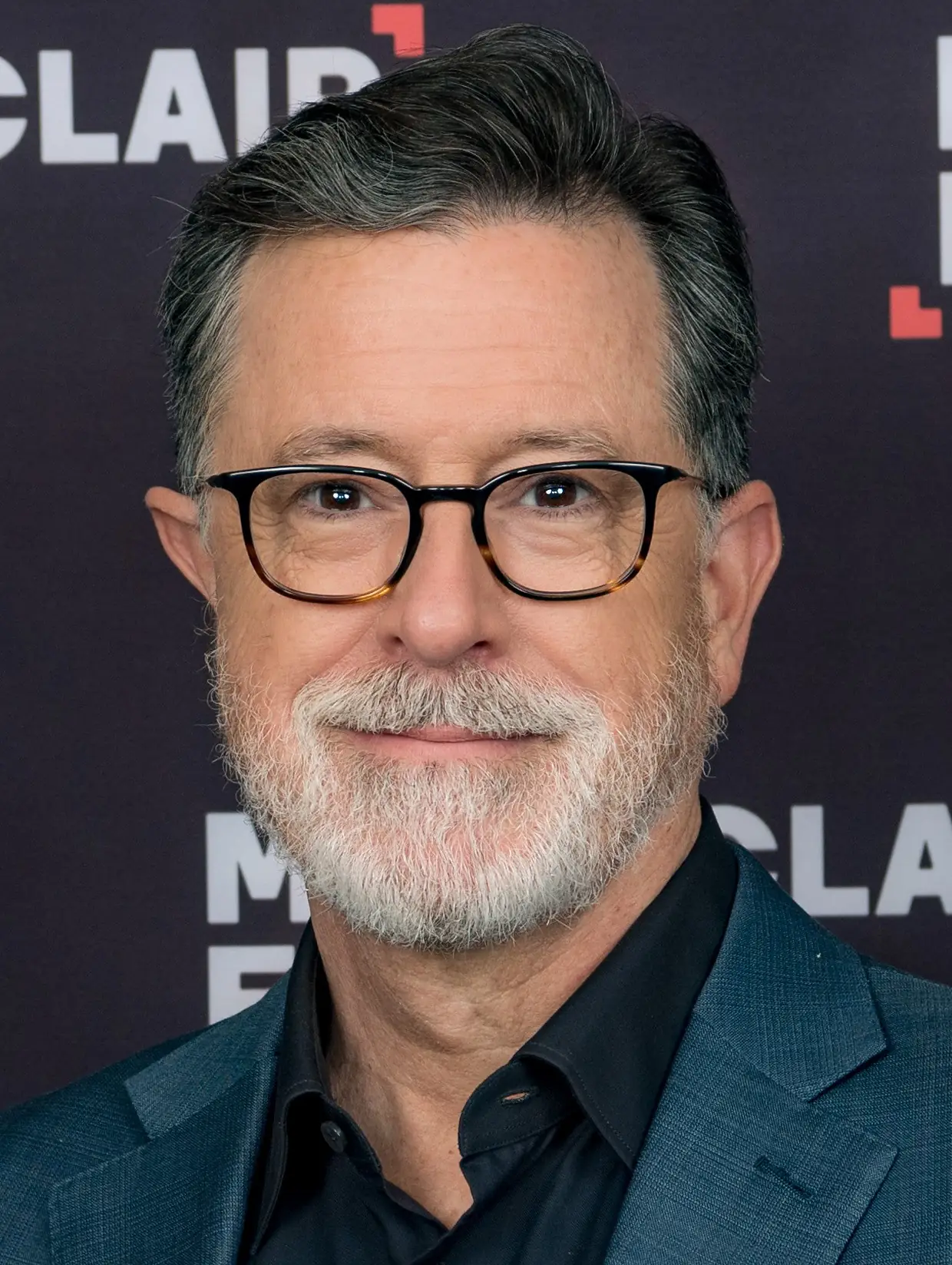 Portret van presentator Stephen Colbert met bril en grijze baard