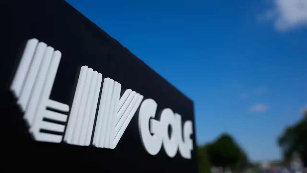 Het LIV Golf-logo op een zwart bord, van onderaf gefotografeerd tegen een blauwe lucht