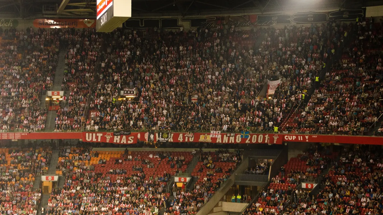 Een volle tribune in de Johan Cruijff ArenA met een grote spandoek van supportersgroep Vak 410