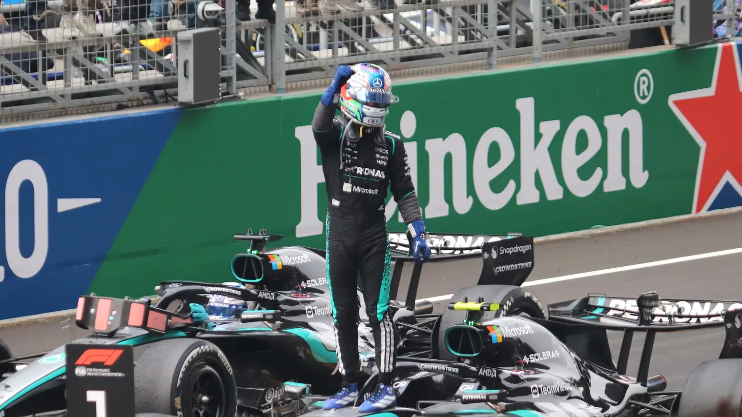 Kimi Antonelli viert zijn overwinning staand op zijn Mercedes-Formule 1-wagen, met de vuist in de lucht