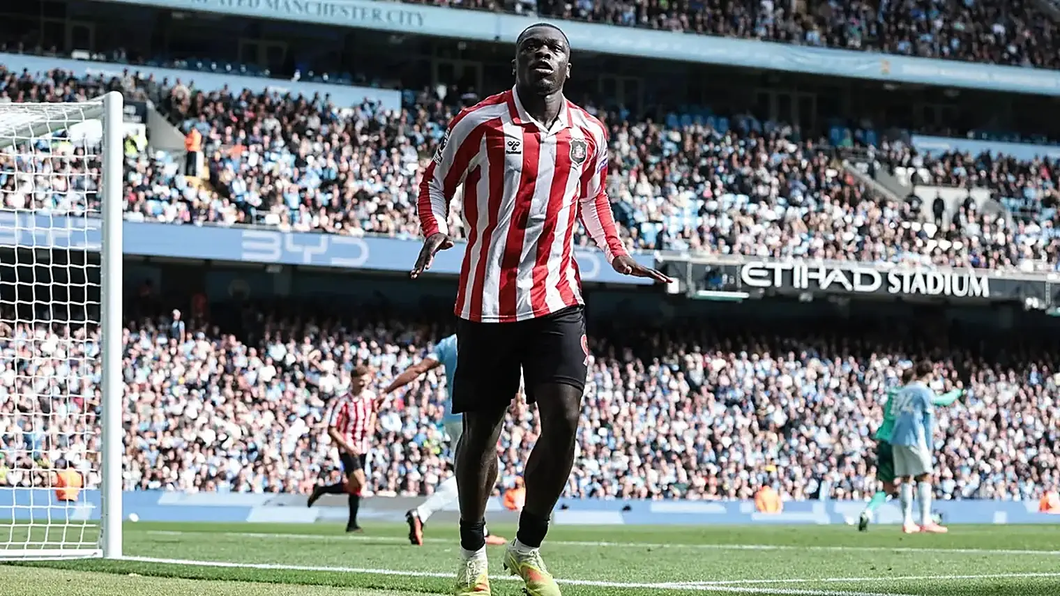 Brian Brobbey viert een doelpunt in het rood-witte shirt van Sunderland, met het Etihad Stadium en het publiek op de achtergrond