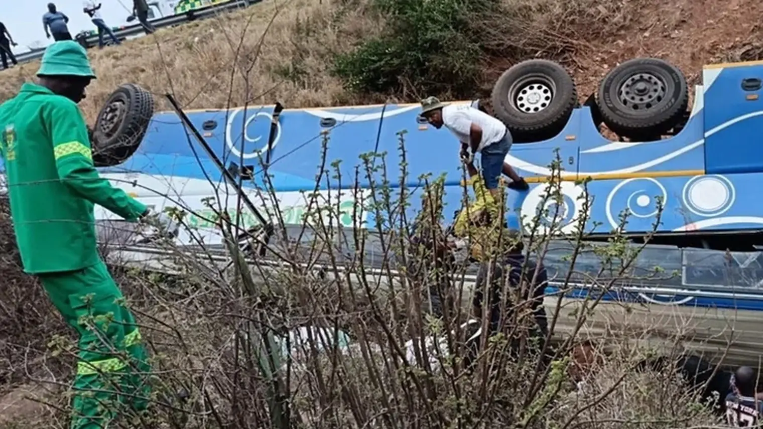 Hulpverleners bij een omgekantelde blauwe bus in een ravijn op het Kaapverdische eiland Fogo