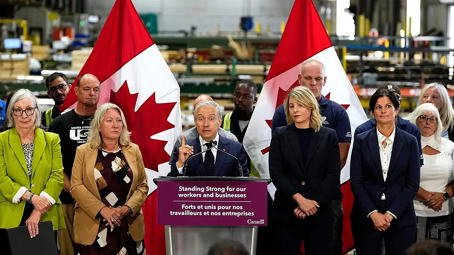 Canadese bewindslieden achter een spreekgestoelte met Standing Strong for our workers