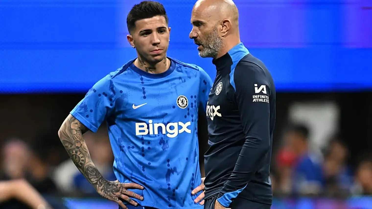 Enzo Fernandez en trainer Enzo Maresca in blauwe Chelsea-trainingskleding op het veld