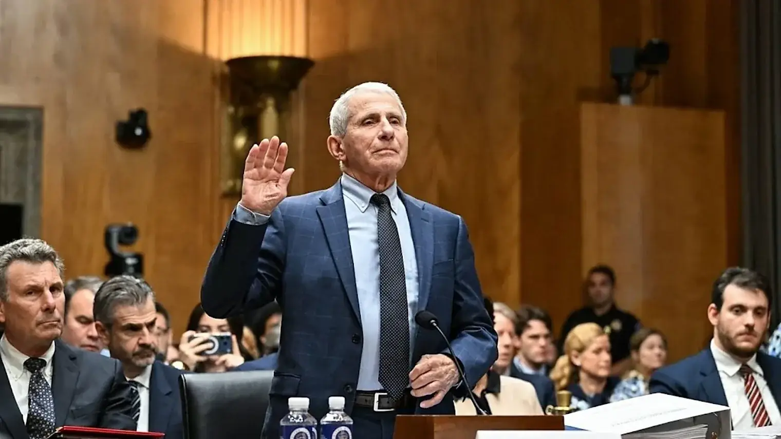 Anthony Fauci staat met opgeheven rechterhand achter de getuigentafel om de eed af te leggen bij een hoorzitting in de Senaat