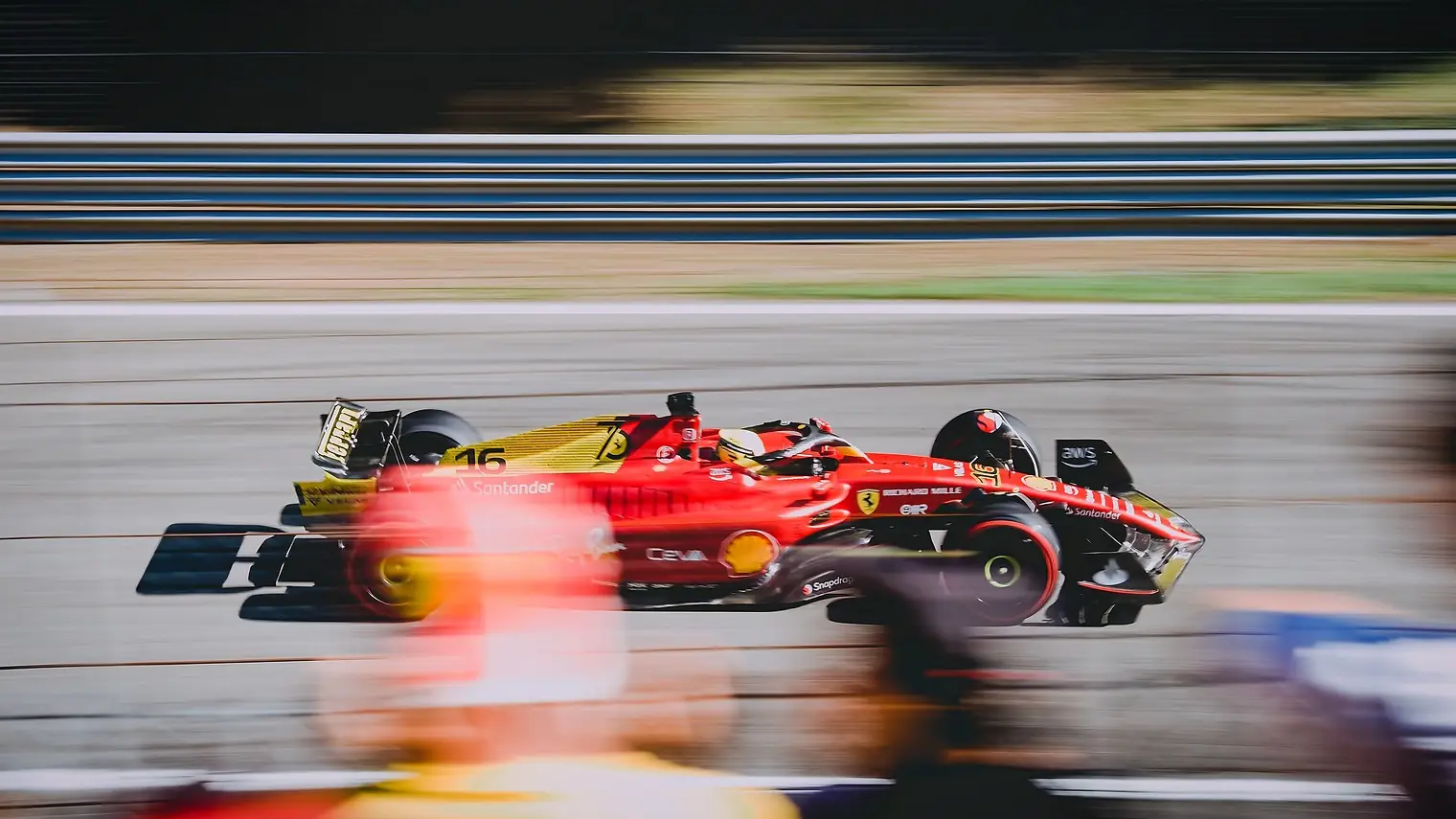 Een rode Ferrari-Formule 1-wagen met wazige achtergrond scheurt over het circuit van Monza