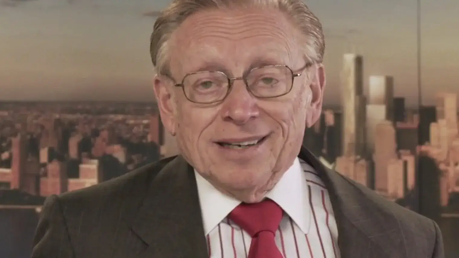 Portret van vastgoedondernemer Larry Silverstein in pak met rode stropdas, met de skyline van New York op de achtergrond