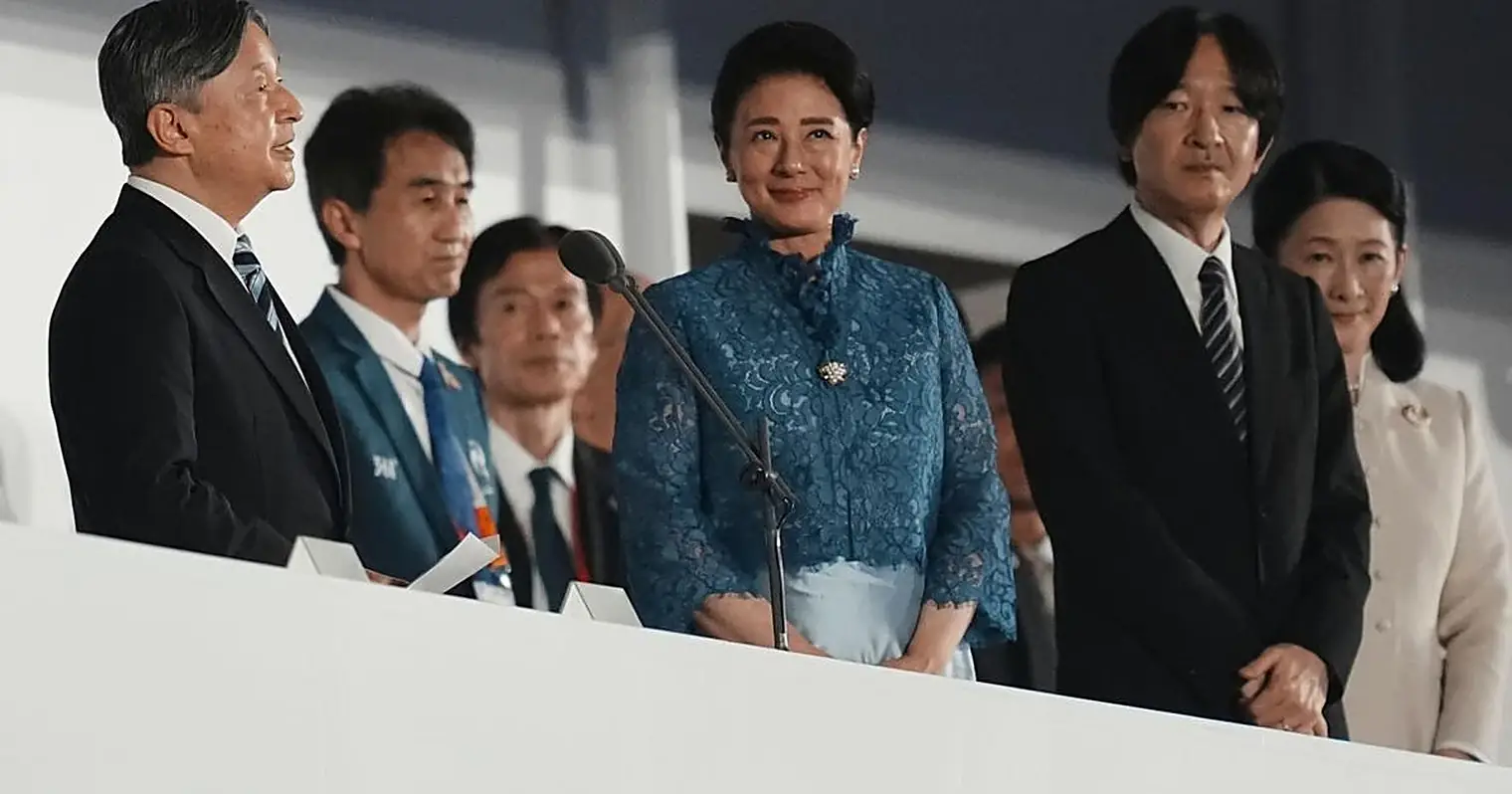 Keizer Naruhito, keizerin Masako, kroonprins Akishino en prinses Kiko staan naast elkaar op een tribune tijdens de openingsceremonie