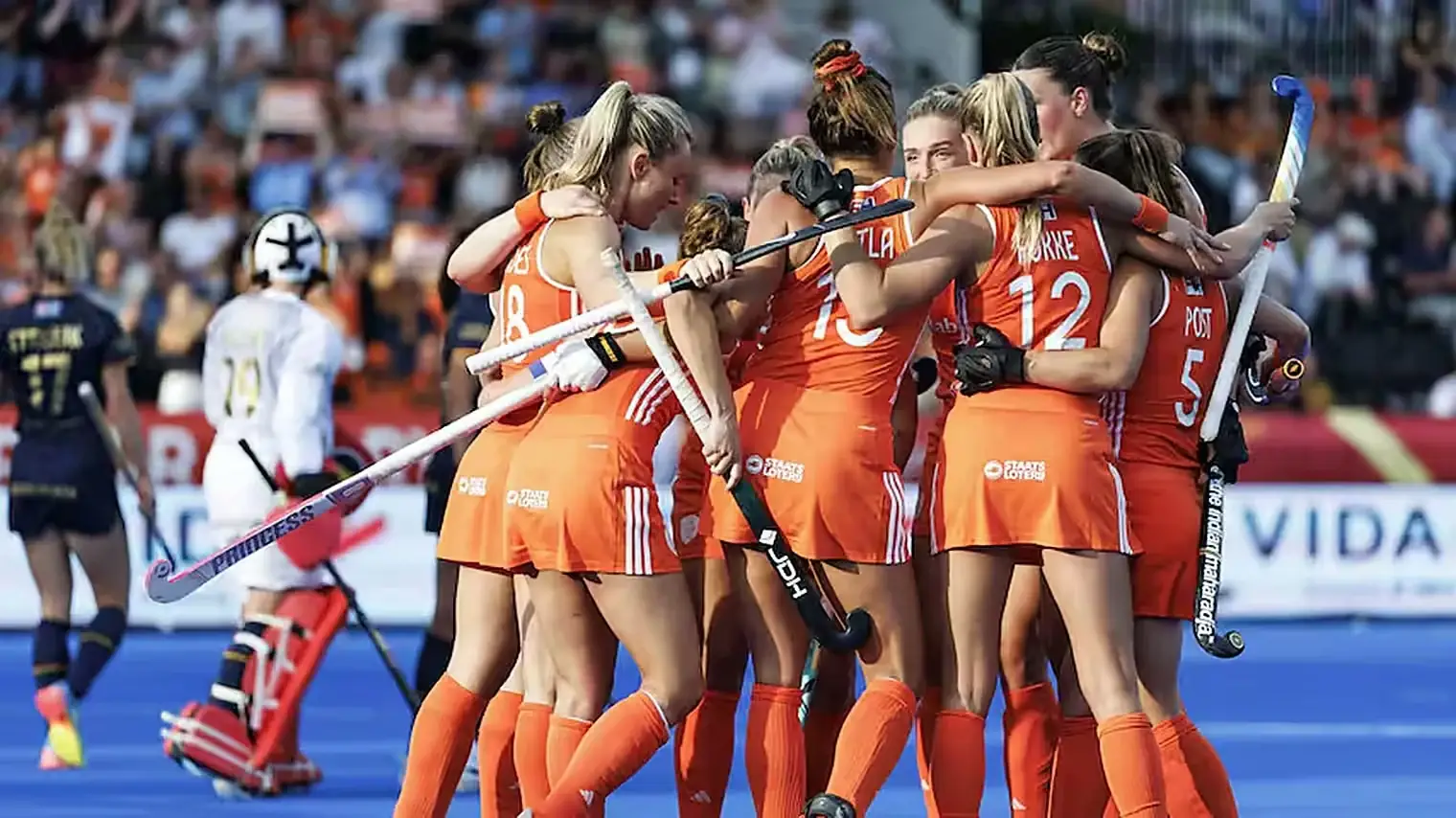 Nederlandse hockeysters in oranje tenue omhelzen elkaar na de treffer van Matla, met de Belgische keepster teleurgesteld op de achtergrond