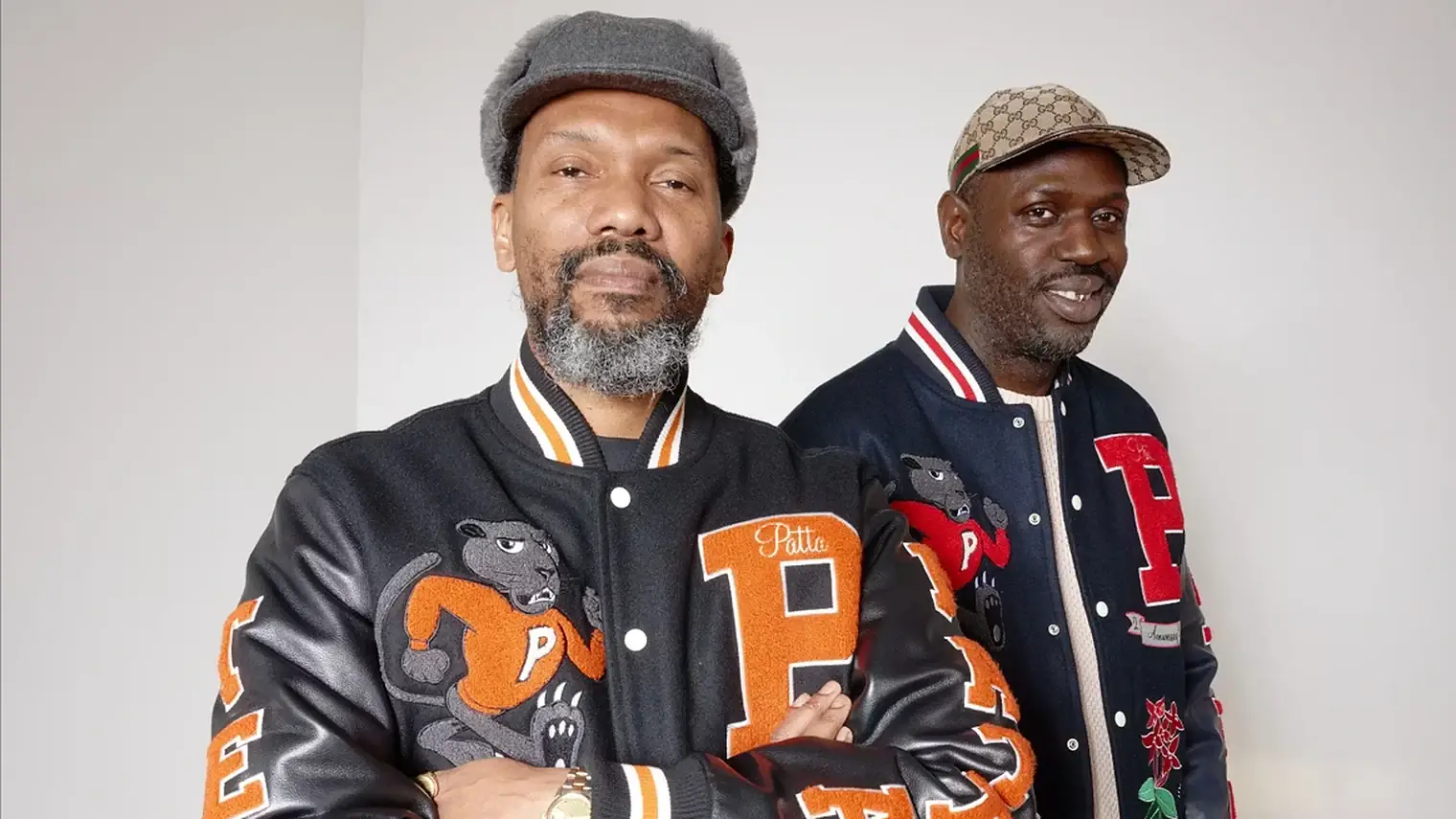 Patta-oprichters Edson Sabajo en Guillaume "Gee" Schmidt in zwarte en donkerblauwe Patta-collegejacks met pantervignet