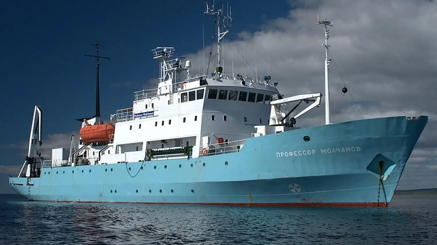 Het onderzoeksschip Professor Molchanov op open water, met de Cyrillische scheepsnaam op de turkooizen boeg en een oranje reddingssloep op het dek