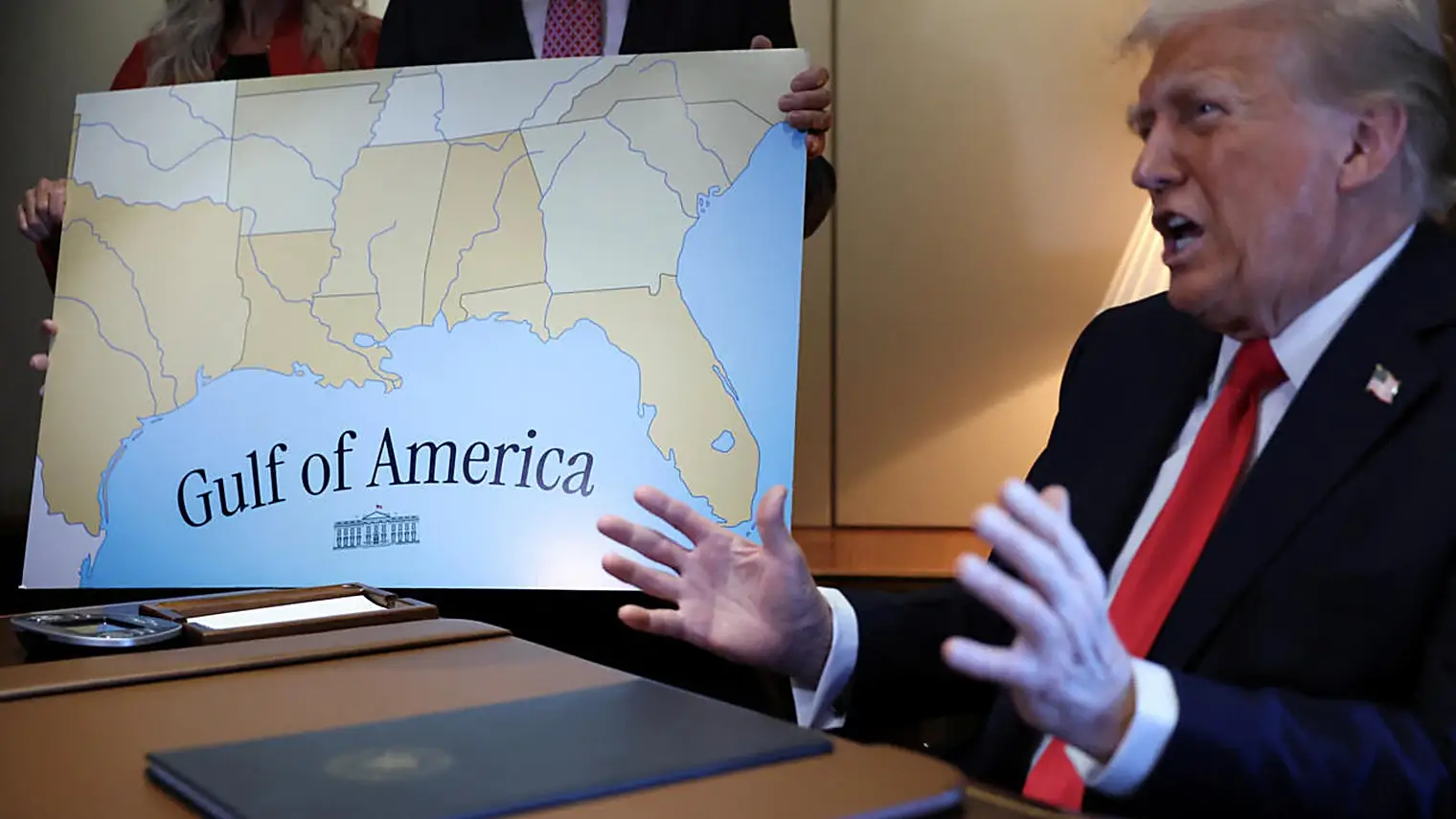 Trump gebaart naast een groot bord met een kaart van de Golf van Mexico waarop Gulf of America staat