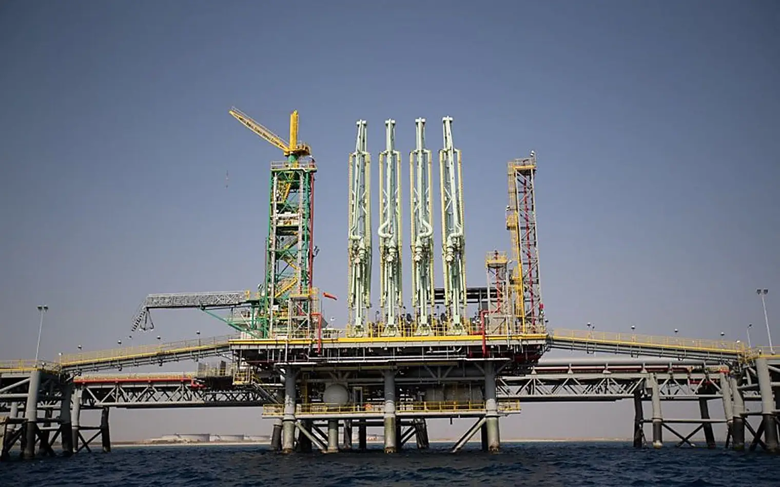 Laadinstallatie van een olieterminal in zee bij Yanbu, met gele en groene laadarmen boven het water