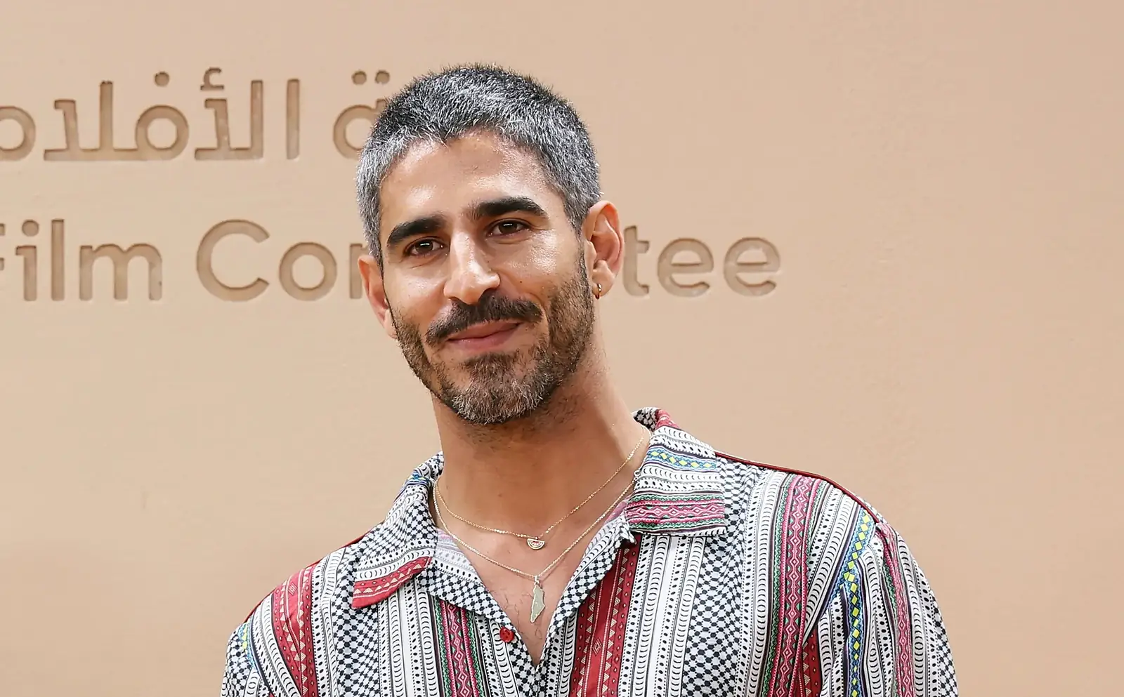 Ahmed Shihab-Eldin kijkt in de camera voor een wand met de tekst Film Committee