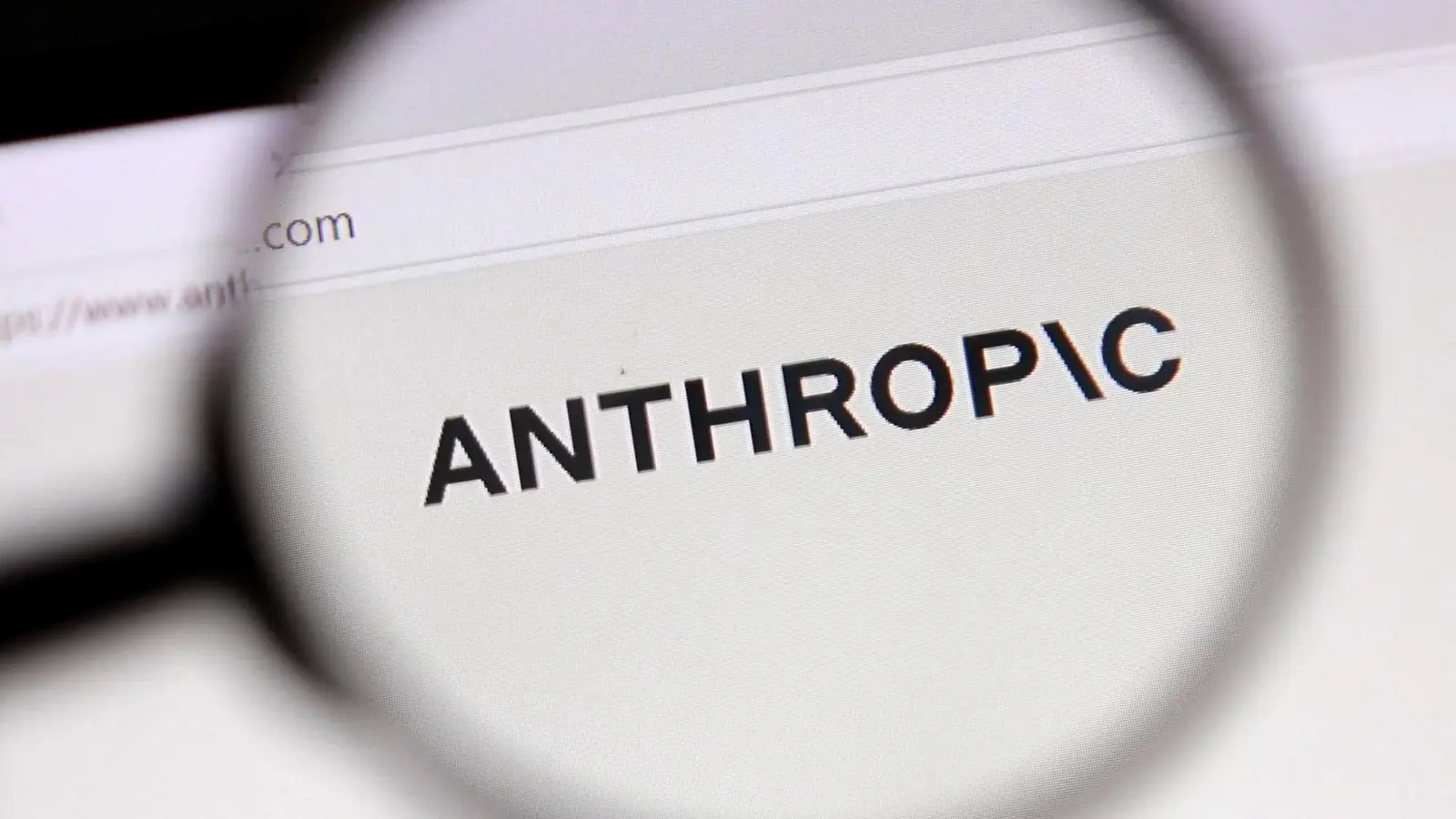 De naam Anthropic vergroot bekeken door een loep op een computerscherm