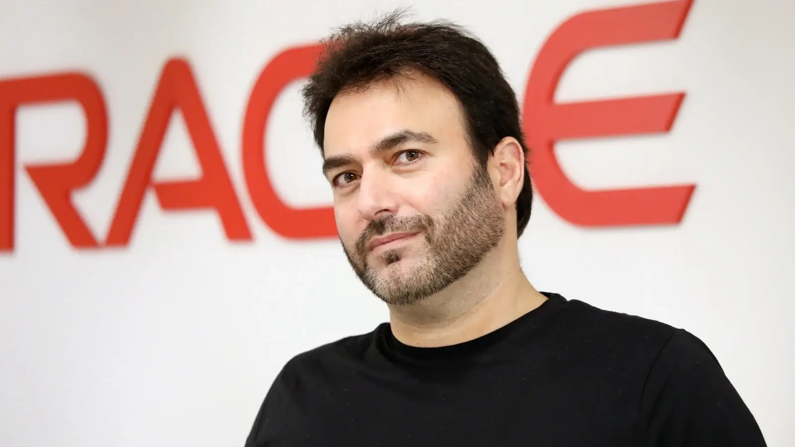 Eran Feigenbaum, hoofd van Oracle Israël, poseert voor een groot Oracle-logo