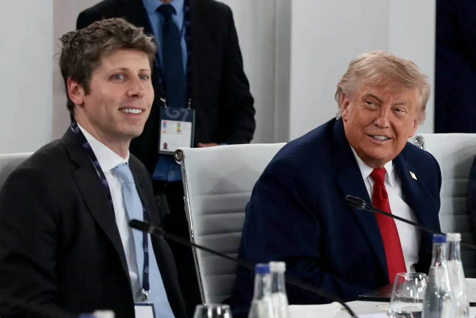 Donald Trump en OpenAI-topman Sam Altman naast elkaar aan een vergadertafel tijdens een G7-top