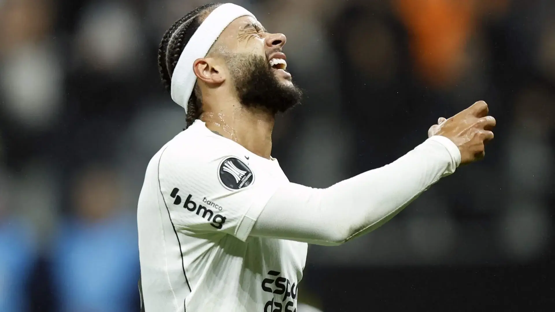 Memphis Depay schreeuwt met zijn hoofd achterover en zijn arm gestrekt in het shirt van Corinthians