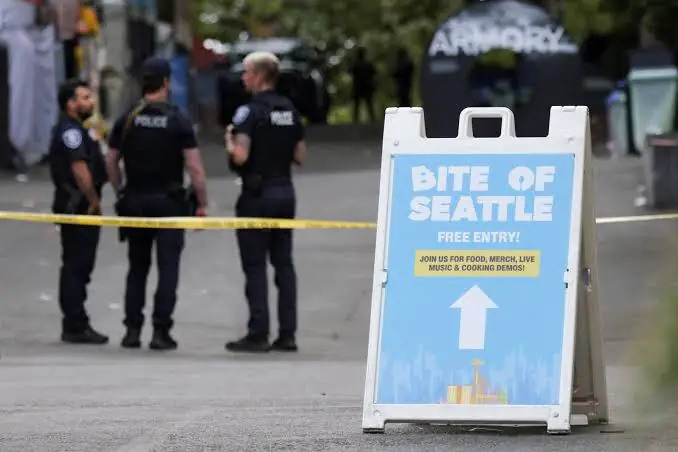 Politieauto met zwaailichten bij een afgezet festivalterrein in Seattle, met de Space Needle op de achtergrond