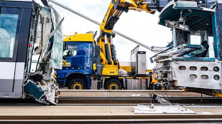 Beschadigde trams worden geborgen door een kraanwagen na de botsing op de Erasmusbrug