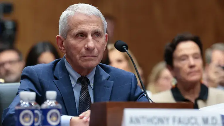 Anthony Fauci in donkerblauw pak achter de getuigentafel bij een hoorzitting in de Amerikaanse Senaat, met microfoon en naambordje voor hem