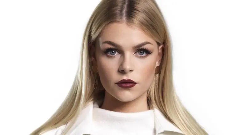 Portret van Davina Michelle met lang blond haar en donkerrode lippenstift tegen een witte achtergrond
