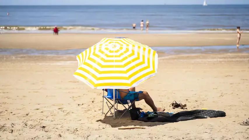 Zonnige zomerdag met mensen op een terras onder een strakblauwe lucht
