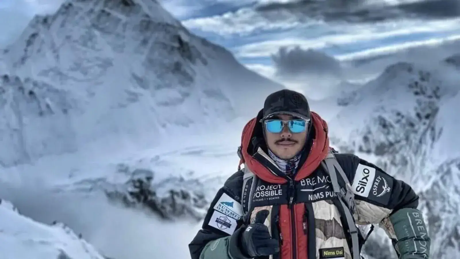 Nirmal Purja in expeditiejas met de tekst Project Possible en Nims Dai op een besneeuwde helling boven de wolken